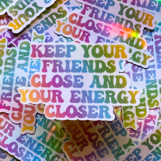 Sticker that Says: Keep your friends close and your energy closer written in a rainbow ombré   background: white